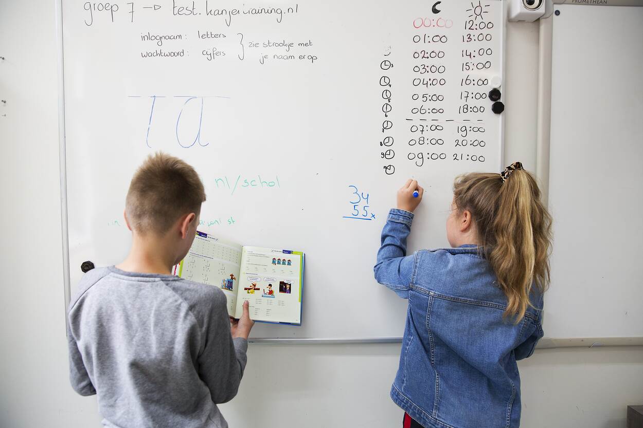 Twee kinderen schrijven op een whiteboard