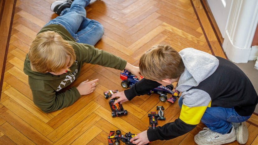 Cover van magazine Jeugdautoriteit. Twee kinderen spelen op de grond met raceauto's