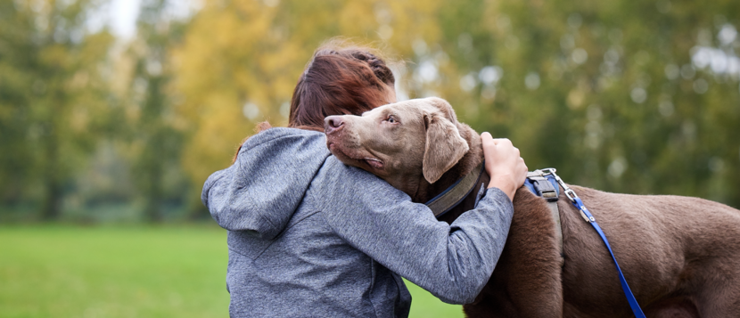 Anna omhelst een hond.