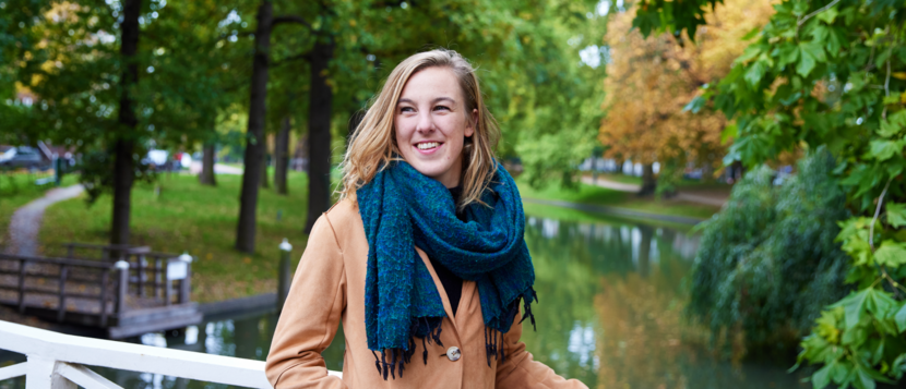 Britt Louter, coördinator van de Augeo Jongerentaskforce. Ze is gefotografeerd op een brug in een park.