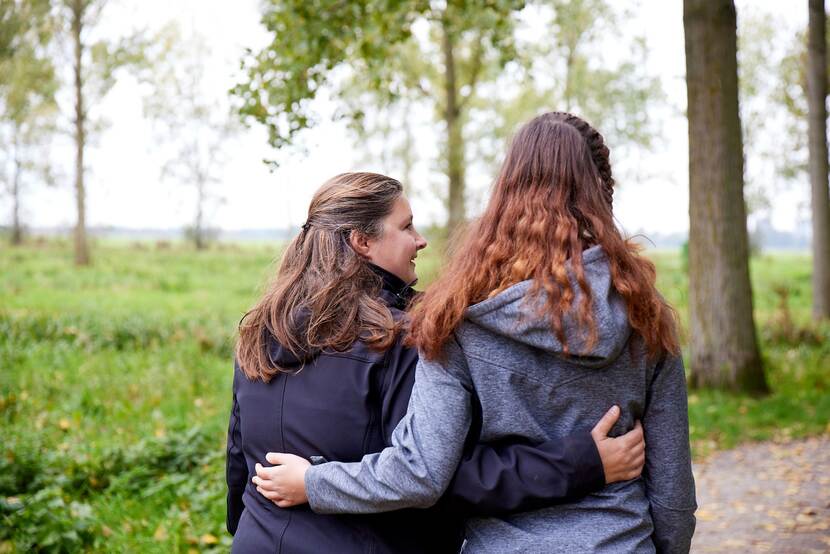 Anna en gezinshuisouder Katja omhelzen elkaar.