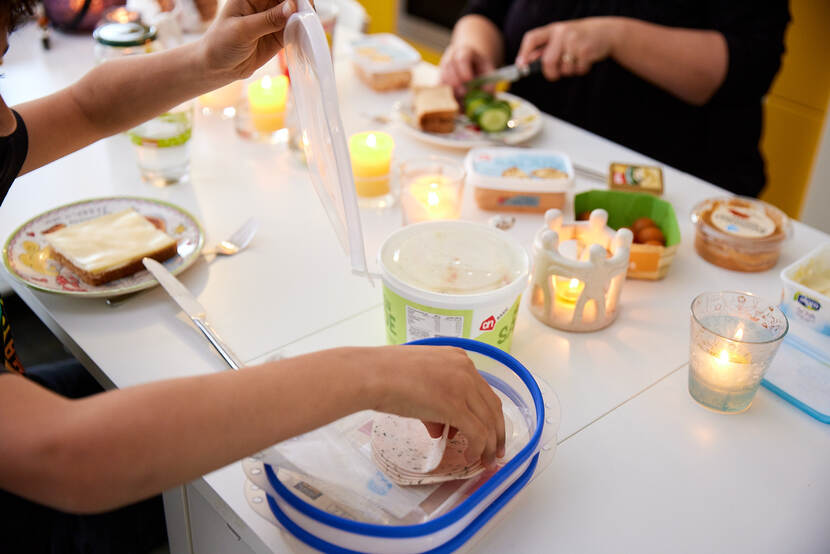 Mensen zitten aan tafel te ontbijten.