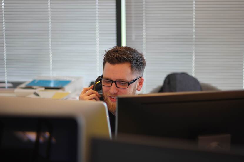 Witte man in kantoor aan de telefoon