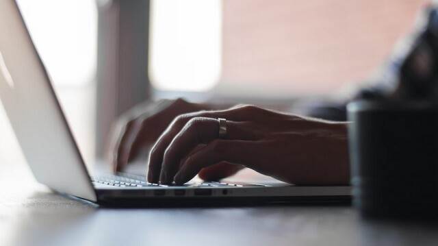 Afbeelding van een persoon achter een laptop